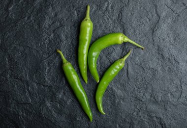 Siyah arka planda taze acı biber yığınının en üst görüntüsü