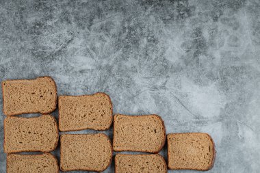 Gri arka planda taze kahverengi ekmek dilimleri