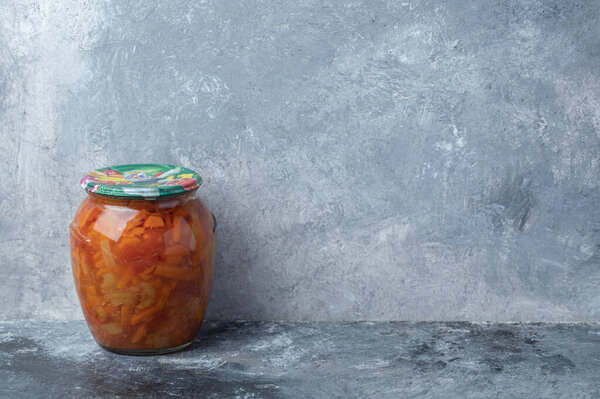Стеклянная банка со смешанными овощами на мраморном фоне