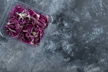 Yeni doğranmış mor lahanayla dolu plastik kabın üst görüntüsü.