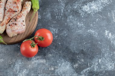 Çiğ baharatlı tavuk budu, yeşil biber ve domates.