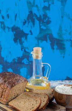 Tahta tabakta yağlı ve unlu kahverengi ekmek dilimleri.