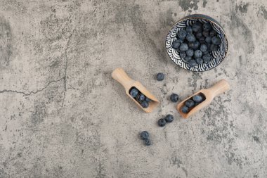 Mermer yüzeyde taze yaban mersini seramik kase