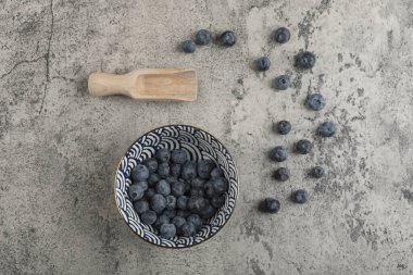 Mermer yüzeyde taze yaban mersini seramik kase