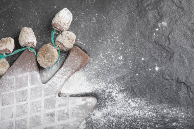 Siyah yüzeyde un ile süslenmiş kurumuş hurma ağaçları.