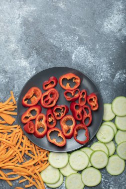 Mermer arka planda dilimlenmiş sebzelerin çeşitliliği