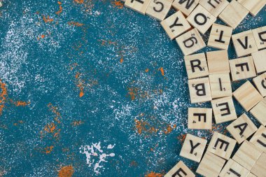 Üzerinde mavi arkaplan yazılı harfler olan tahta zarlar.