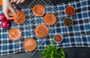 Izgaradan ızgara salam dilimleri alan bir kadın.