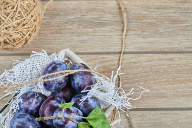 Bahçe erikleri ahşap bir masada sepetin içinde.