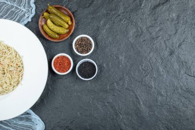 Lezzetli erişte ve turşu turşulu beyaz bir tabak.