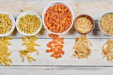 Tahta masadaki pişmemiş makarna kaselerinin çeşitleri.