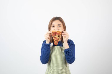 Beyaz arka planda pizza dilimini gösteren önlüklü kadın portresi