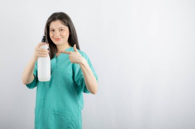 Dezenfektanı gösteren genç bir kadın.