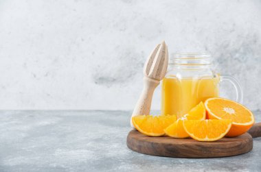 Taş zemin üzerinde taze portakal meyveleri olan cam bir sürahi meyve suyu. Yüksek kalite fotoğraf