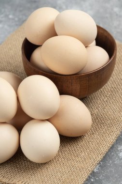 Mermer yüzeyde tahtadan bir kase organik çiğ yumurta. Yüksek kalite fotoğraf