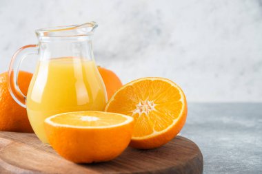 Taş zeminde portakal suyu dilimleriyle dolu tahta bir tahta.