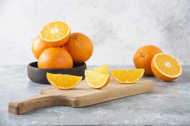 Taş zeminde portakal suyu dilimleriyle dolu tahta bir tahta.