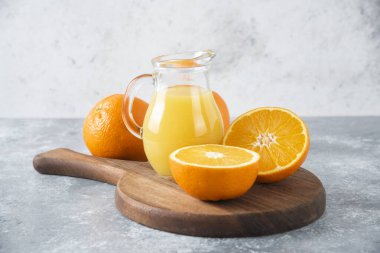 Taş zeminde portakal suyu dilimleriyle dolu tahta bir tahta.