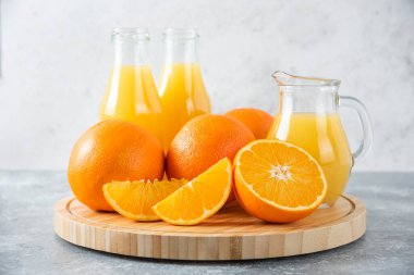 Taş zeminde portakal suyu dilimleriyle dolu tahta bir tahta.