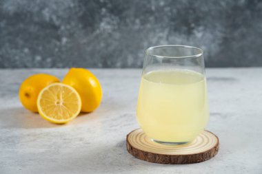 Tahtanın üzerinde bir bardak taze limon suyu.