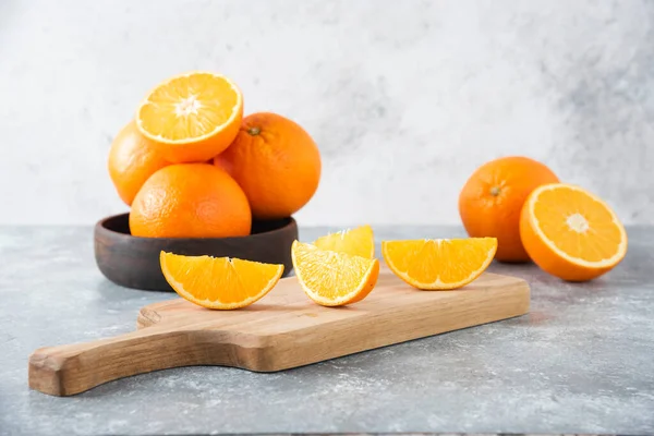 Taş zeminde portakal suyu dilimleriyle dolu tahta bir tahta.