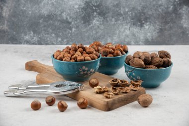 Tahta üzerinde ceviz, fındık ve çekirdek kaseleri