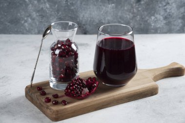 Bir sürahi dolusu nar ve bir bardak meyve suyu.