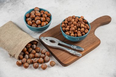 Çuval bezinde organik kabuklu fındık yığını ve içinde çekirdekler var.