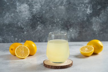 Tahtanın üzerinde bir bardak taze limon suyu.