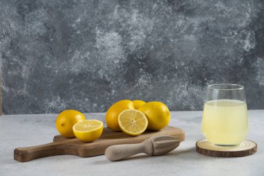 Tahtanın üzerinde bir bardak taze limon suyu.