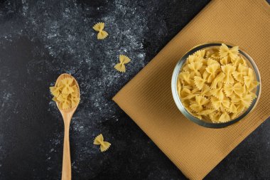 Bir kase çiğ makarna ve kaşık.