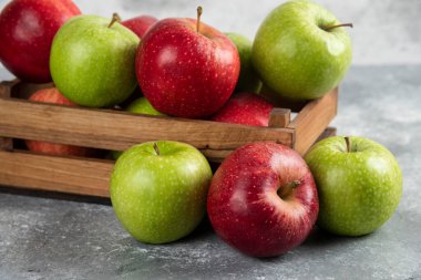 Tahta kutuda taze yeşil ve kırmızı elmalar.