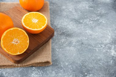 Taş zeminde portakal suyu dilimleriyle dolu tahta bir tahta.