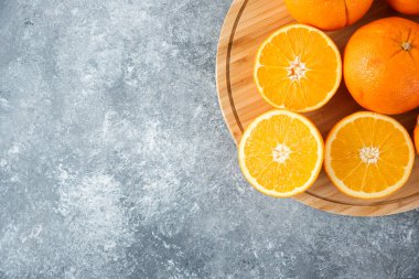 Taş zeminde portakal suyu dilimleriyle dolu tahta bir tahta.