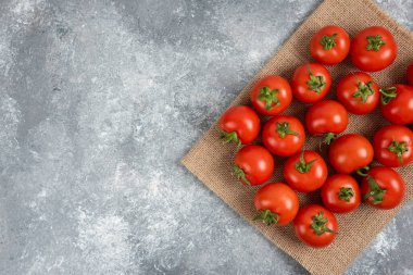 Mermer yüzeyinde çuval bezli kırmızı taze domatesler.