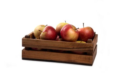 Beyaz arka planda izole edilmiş tahta bir sandıkta taze elmalar.