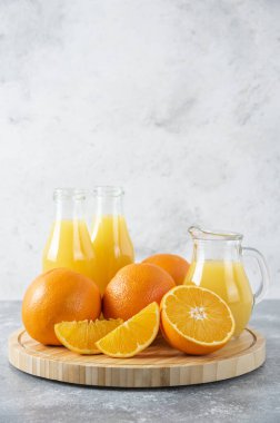 Taş zeminde portakal suyu dilimleriyle dolu tahta bir tahta.