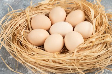 Mermer yüzeyinde kuş yuvası olan çiğ yumurtalar.