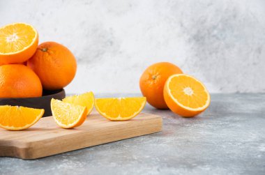 Taş zeminde portakal suyu dilimleriyle dolu tahta bir tahta.