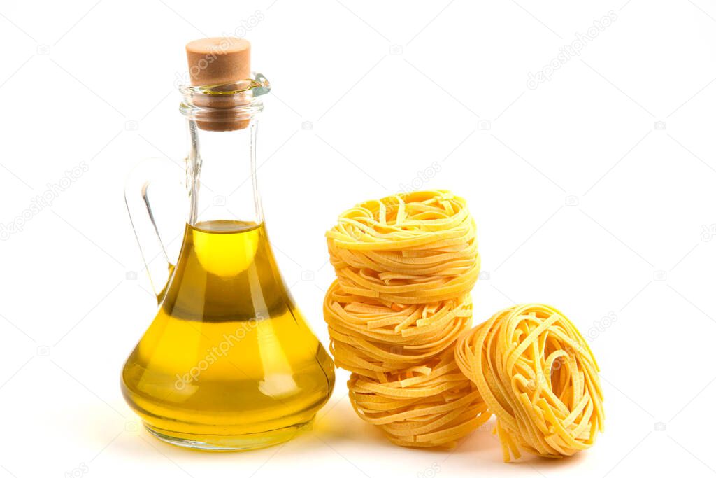 Uncooked pasta nests and bottle of oil on white background