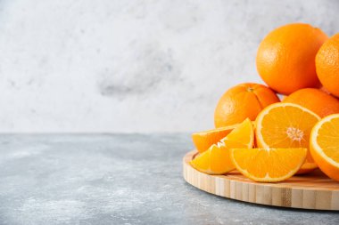 Taş zeminde portakal suyu dilimleriyle dolu tahta bir tahta.