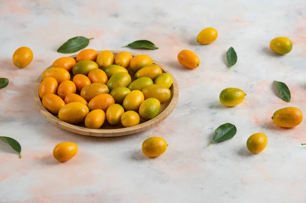 Close up photo, Pile of kumquats on wooden plate — Stock Photo, Image