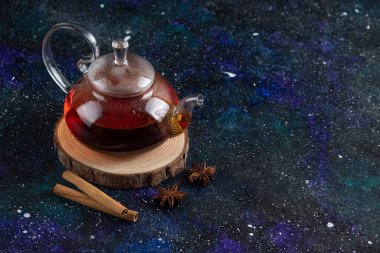 Tahtada tarçın olan cam çaydanlık.