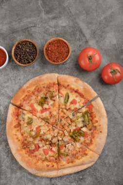 Lezzetli tavuk pizzası ve taştan arka planda çeşitli baharatlar. Yüksek kalite fotoğraf