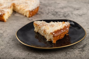 Kek dilimleri ve hindistan cevizi dilimleri bir taş masaya konur. Yüksek kalite fotoğraf