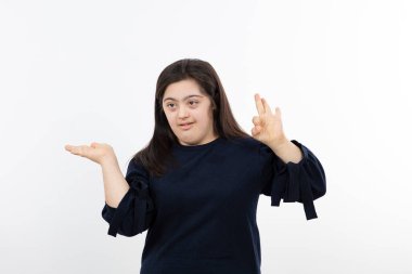 Ayakta duran ve poz veren Down sendromlu genç bir kız resmi. Yüksek kalite fotoğraf