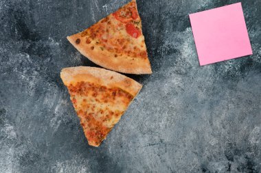 Taş zeminde iki dilim taze pizza ve pembe kağıtlar. Yüksek kalite fotoğraf