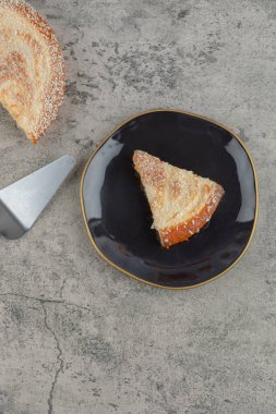 Taş zeminde siyah bir tabak lezzetli vanilyalı kek. Yüksek kalite fotoğraf