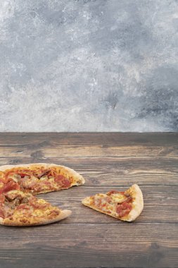 Lezzetli pepperoni ve peynirli pizza ahşap masaya konur. Yüksek kalite fotoğraf