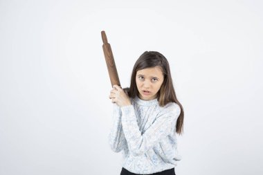 Beyaz arka planda merdane tutan genç bir kadın. Yüksek kalite fotoğraf